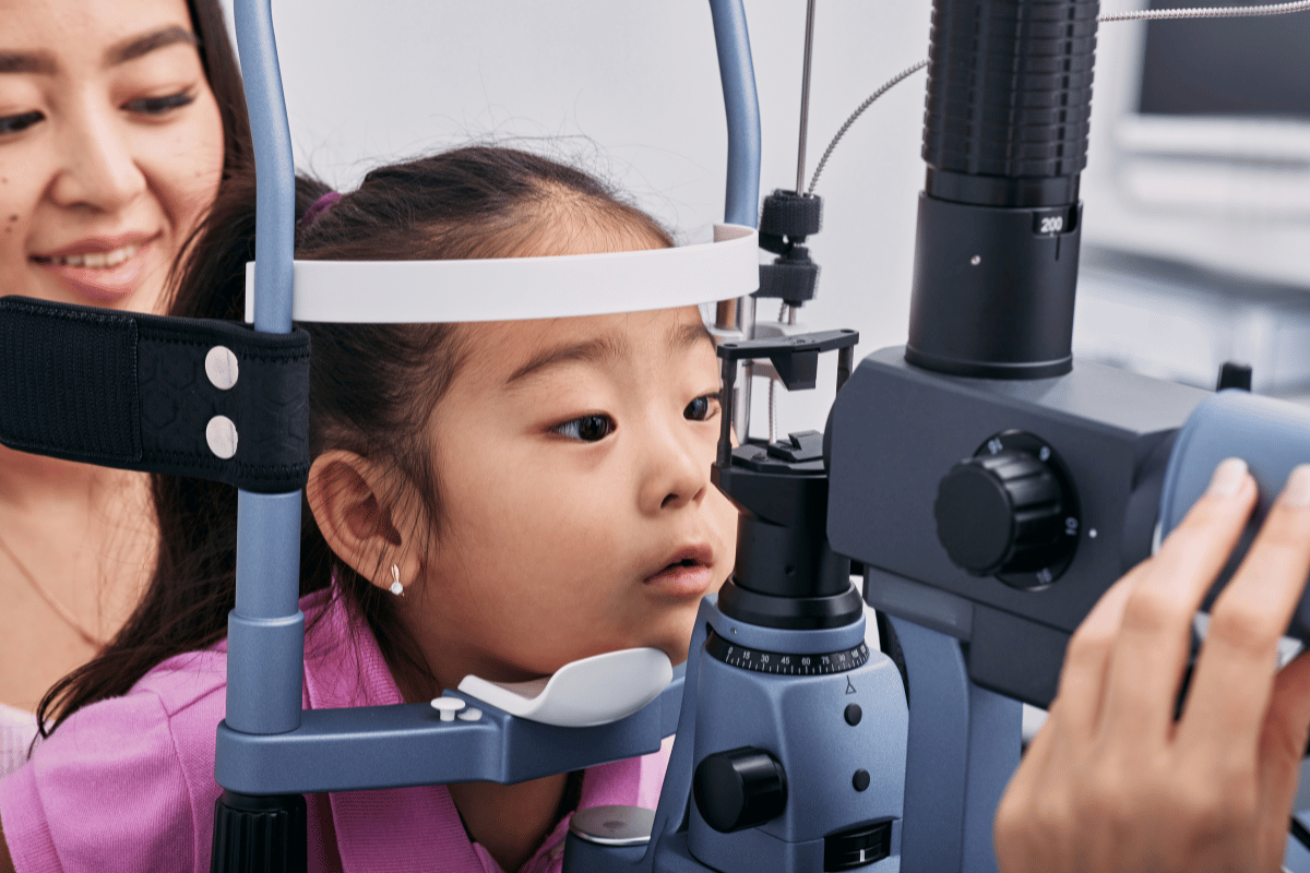 a little girl with her mom getting an eye exam